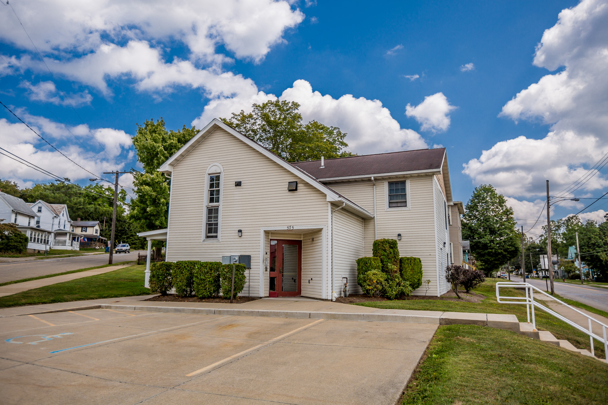 a white house with a driveway and a parking lot